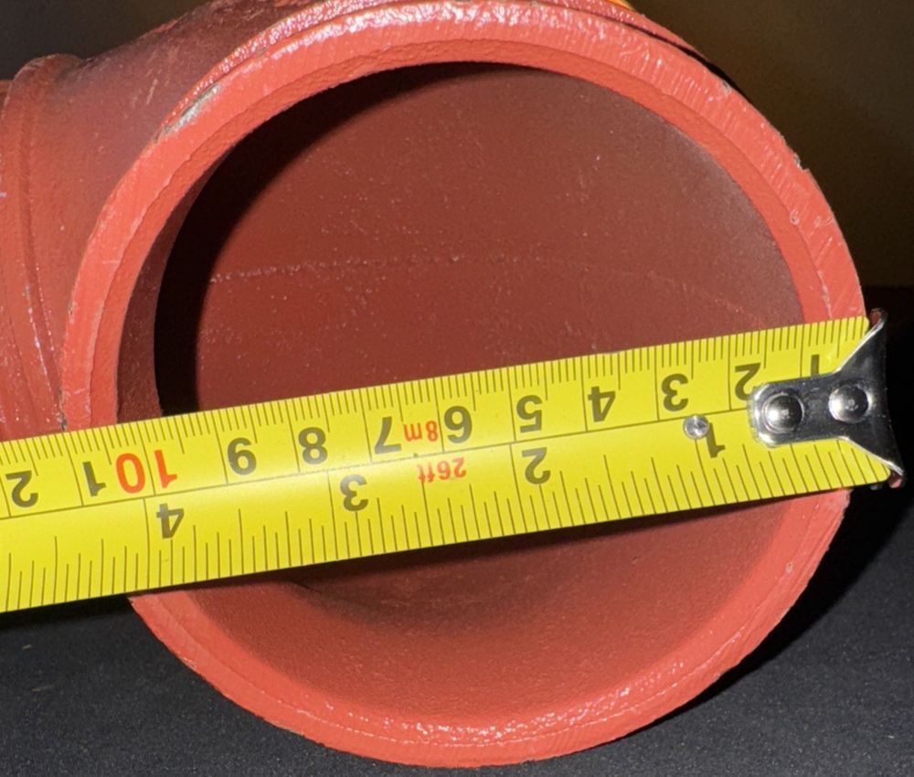Victaulic Firelock Style 001 4/14,3 90-Degree Elbow Grooved End Pipe Fitting – a measuring tape is on a red fire hydra