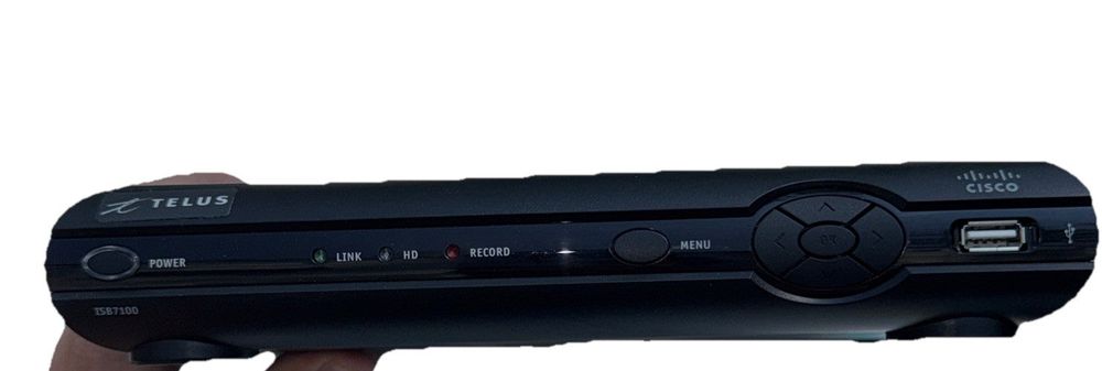 Cisco ISB7100 Internet Protocol Set top Box Streamer No Cables/Controller – a hand holding a black playstation game console