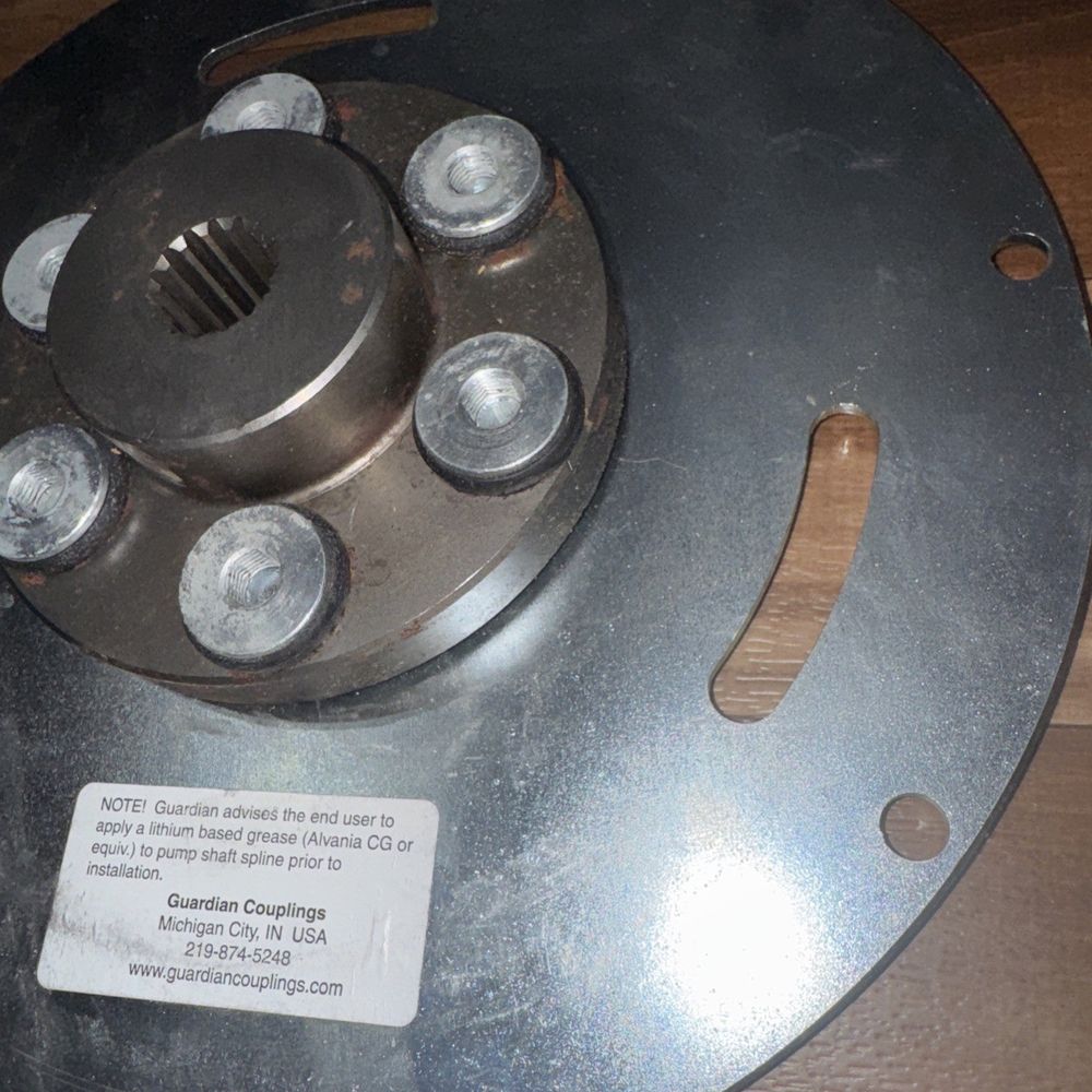 Genie Lift Part #128022GT - Guardian Couplings – a metal object on a wooden table