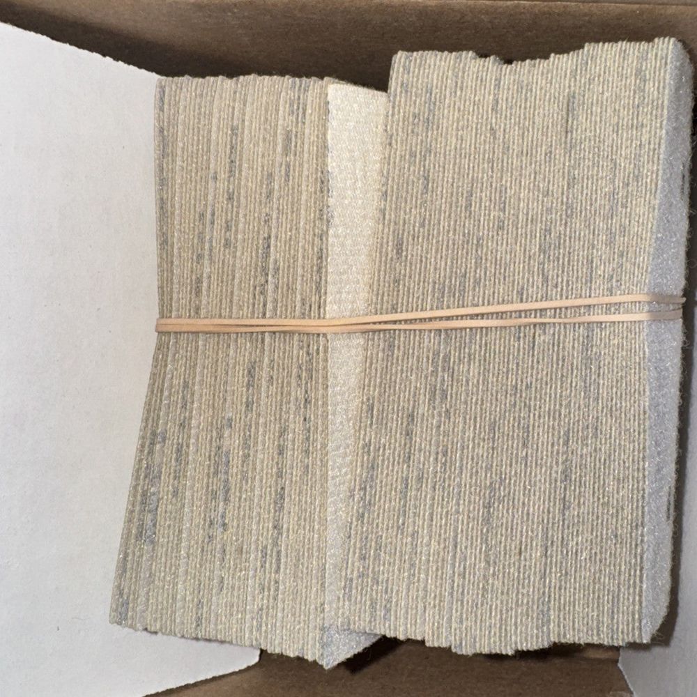Uneeda 3" x 4" EKASTORM Hook & Loop Paper Sanding Sheets 150 Grit 100 Pack – a piece of cardboard with a piece of cardboard on top