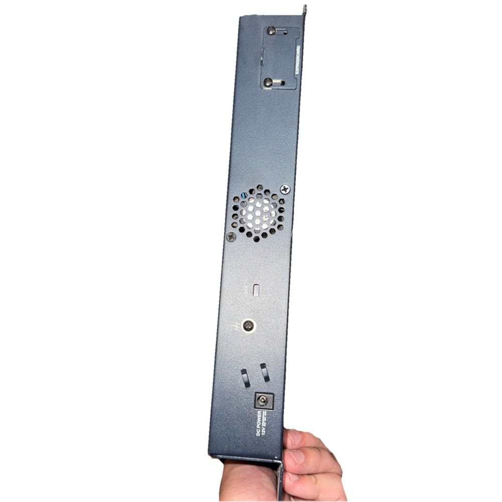 Juniper SRX210 Services Gateway (No Cables) – a hand holding a metal device with a white background
