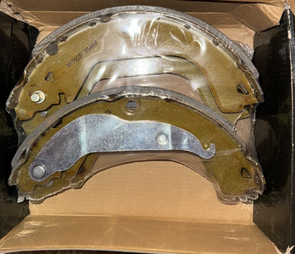 Rear Drum Brake Shoe NB-992B For Chevrolet Cruze Limited, Top Quality – a box with a brake pad and a brake pad