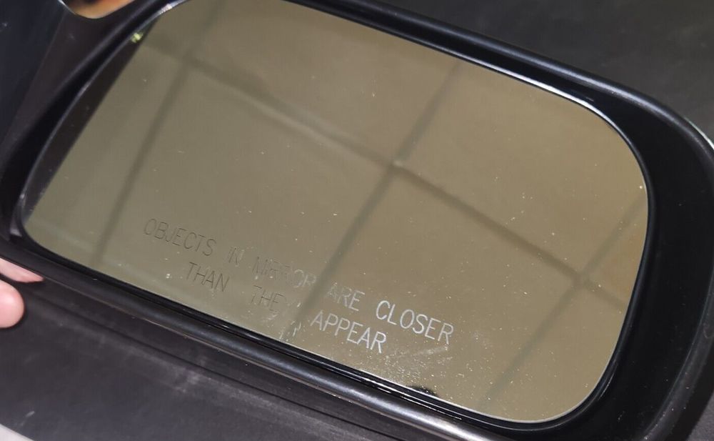 TYC 5210531 Door Mirror Right-Side Compatible with 1997-2001 Toyota Camry – a person holding a mirror with a sign on it