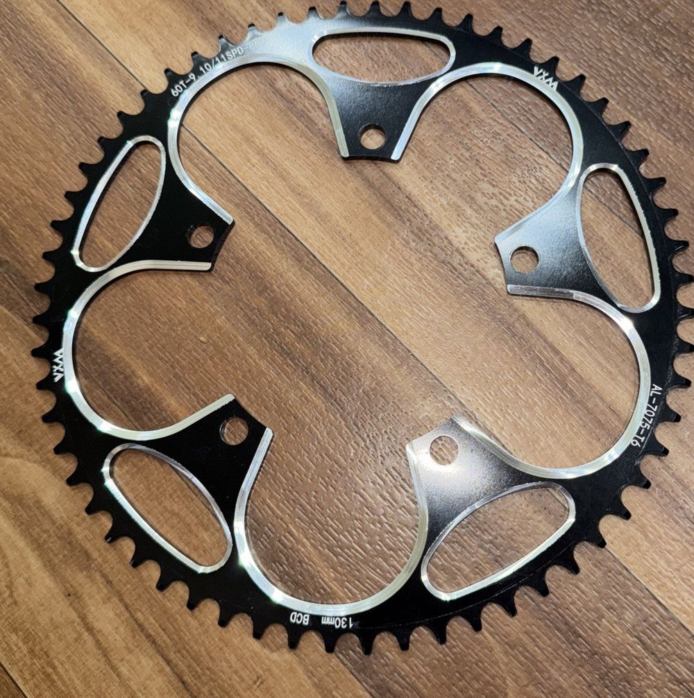 Ybeki 130 BCD Chain Ring Black 60 Teeth – a close up of a bike chainring on a wooden floor