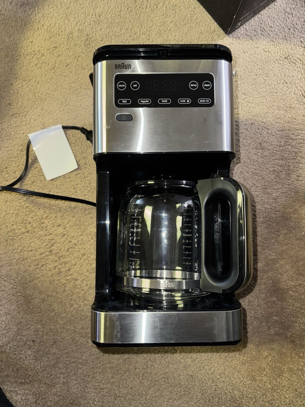 Braun KF5650BK PureFlavor 14-Cup Black & SS Programmable Coffee Maker – a coffee maker on a carpet with a cup of coffee